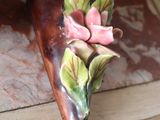a small pink flower on top of a piece of wood