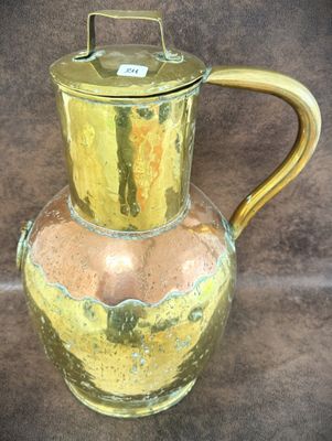 a glass pitcher with a gold handle on a table