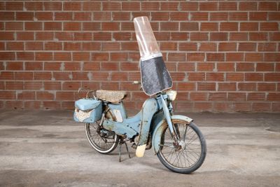 a blue motor bike with a plastic cover on the back