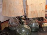 trois lampes en verre vert posées sur une table, avec une horloge en arrière-plan