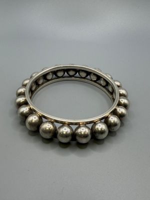 un gros plan d'un bracelet en argent posé sur une table