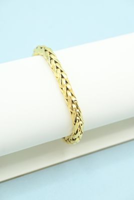 a close up of a gold bracelet sitting on top of a napkin