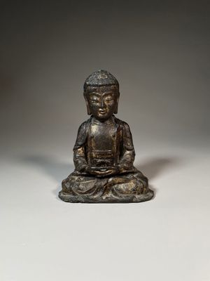 bronze statue of a person sitting in a meditation position