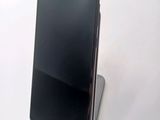 the back of a black cell phone sitting on top of a white surface