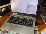 un ordinateur portable posé sur un bureau encombré
