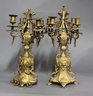 paire de chandeliers anciens en laiton sur pied, sur fond gris