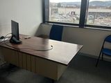 un bureau sur lequel se trouve un ordinateur, avec une chaise placée devant une fenêtre