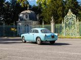 a blue car that is parked in front of a gate