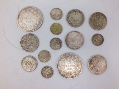 Plusieurs types de pièces de monnaie sont disposées en cercle sur une surface blanche