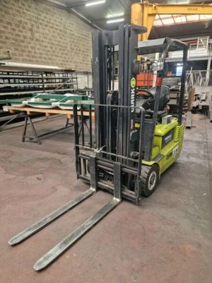 a fork lift truck in a warehouse with several pallets on it
