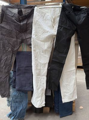 trois paires de jeans suspendues à un portant à l'extérieur