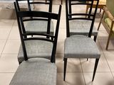 quatre chaises sont alignées en rangée sur un sol carrelé