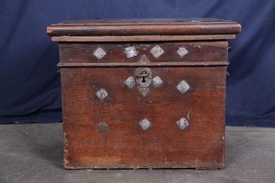une vieille boîte en bois ornée de clous métalliques