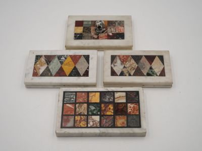 four pieces of art are displayed on a white surface