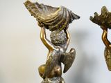 une statue représentant un garçon et une fille tenant un éventail
