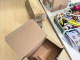 a cardboard box on the table next to a box of pens and pencils