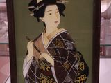 une photo d'une femme en kimono exposée dans une vitrine