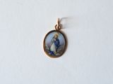a close up of a small pendant with a picture of a woman on it
