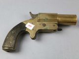 an old brass revolver with a tag on it sitting on a table