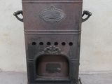 an old stove sitting on the sidewalk in front of a white wall