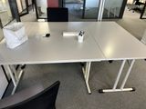 a white table with a black chair in the middle of it