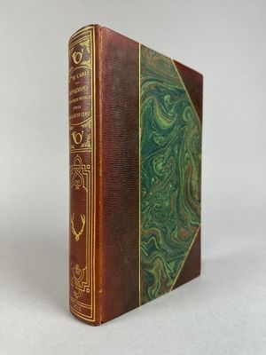 un vieux livre à la couverture verte posé sur une surface blanche