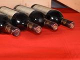 several bottles of wine are lined up on a red table cloth