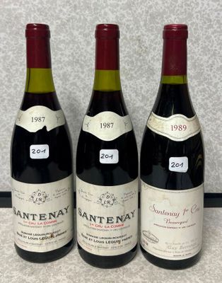 trois bouteilles de vin rouge sont alignées sur un comptoir