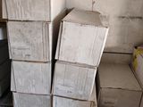 boxes stacked on top of each other in a room next to a refrigerator