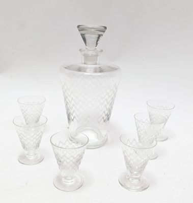 four glasses and a decanter sitting on a table