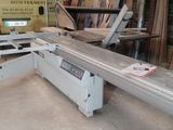 a machine that is cutting a piece of wood in a room