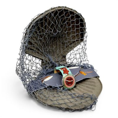 un casier à poissons contenant un poisson, posé sur une surface blanche