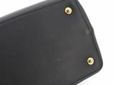 a close up of a black purse on a white surface