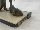 bronze statue of a woman and a duck on a marble base
