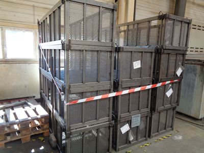 a large stack of crates in a warehouse with red and white tape