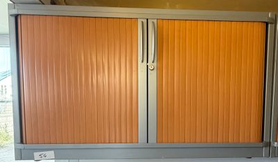 une armoire orange dans une pièce au sol blanc
