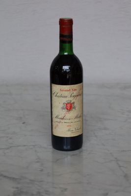 a bottle of wine sitting on a marble counter top