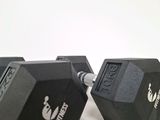 two black dumbbles sitting on a white surface