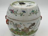 an image of a white and green vase with a bird and flowers on it