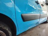 a close up of a blue car with a black door handle
