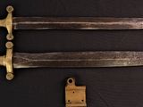 two old knives are sitting next to each other on a black surface