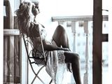 a woman that is sitting in a chair by a window