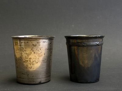 pair of silver cups on a grey background