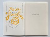 a white notebook with yellow lettering on it and a black pen