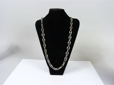 a close up of a necklace on a mannequin on a table