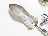 a silver spoon and a bottle opener on a white table
