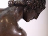 bronze statue of a man kneeling down with his hands on his knees