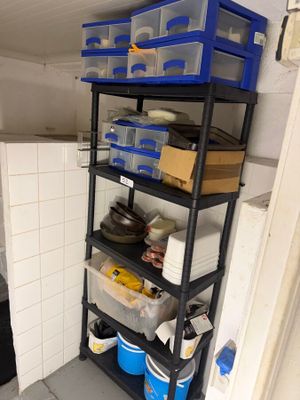 a small room with shelves and bins in it