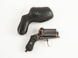 un vieux revolver et un étui en cuir posés sur une surface blanche