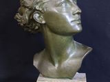 a bronze bust of a woman with curly hair on a marble base
